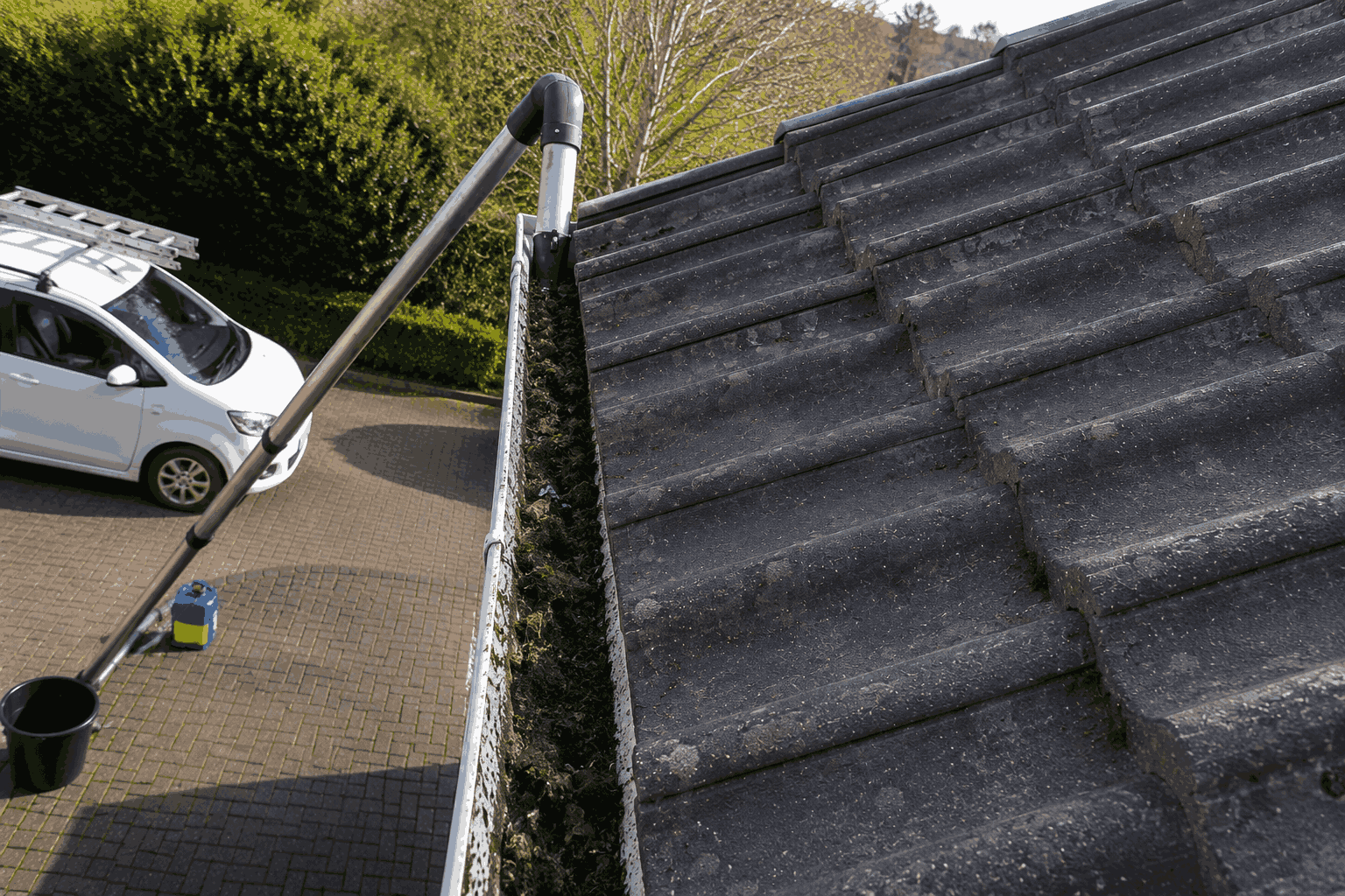 Blocked downpipe before cleaning showing packed mud and debris