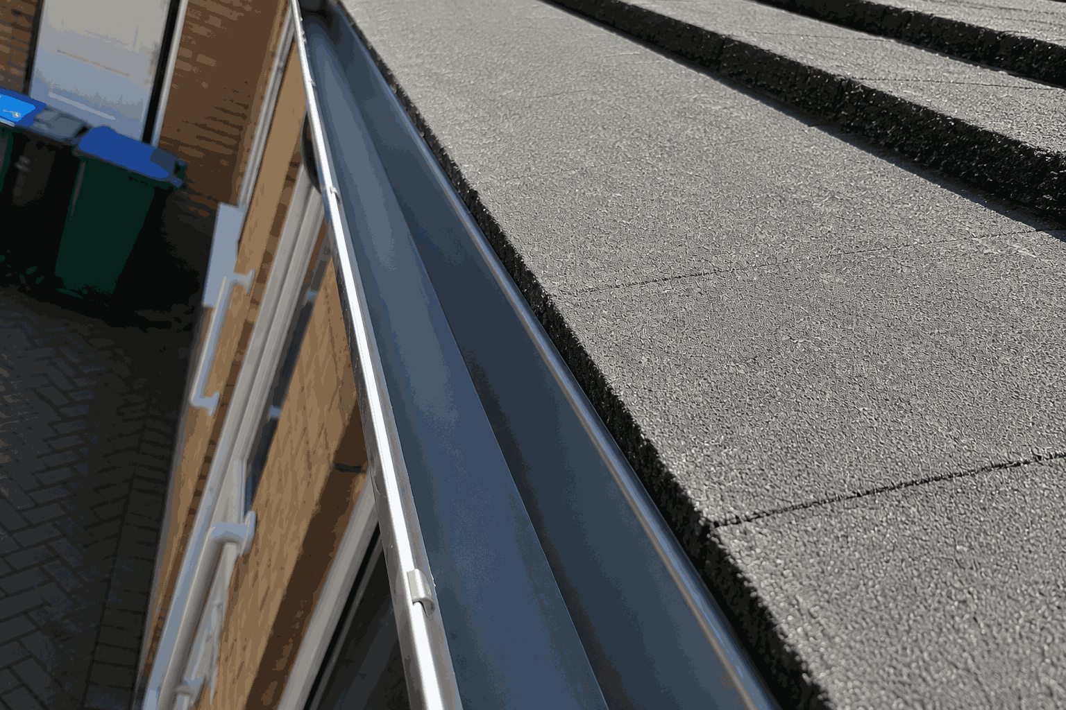 Clean, clear gutter and free-flowing downpipe verified with photo evidence