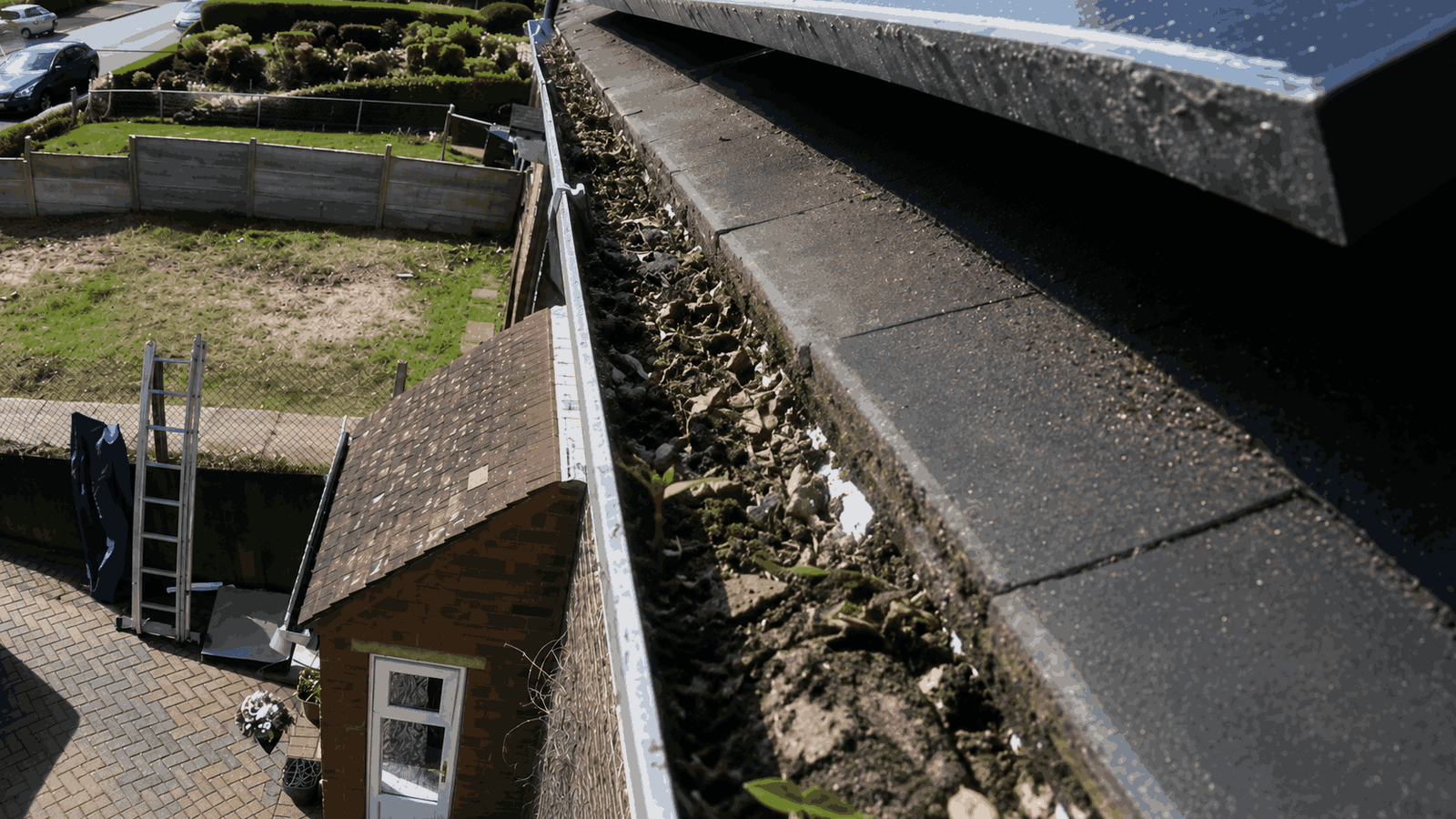 Blocked gutter full of silt and weeds before clearance