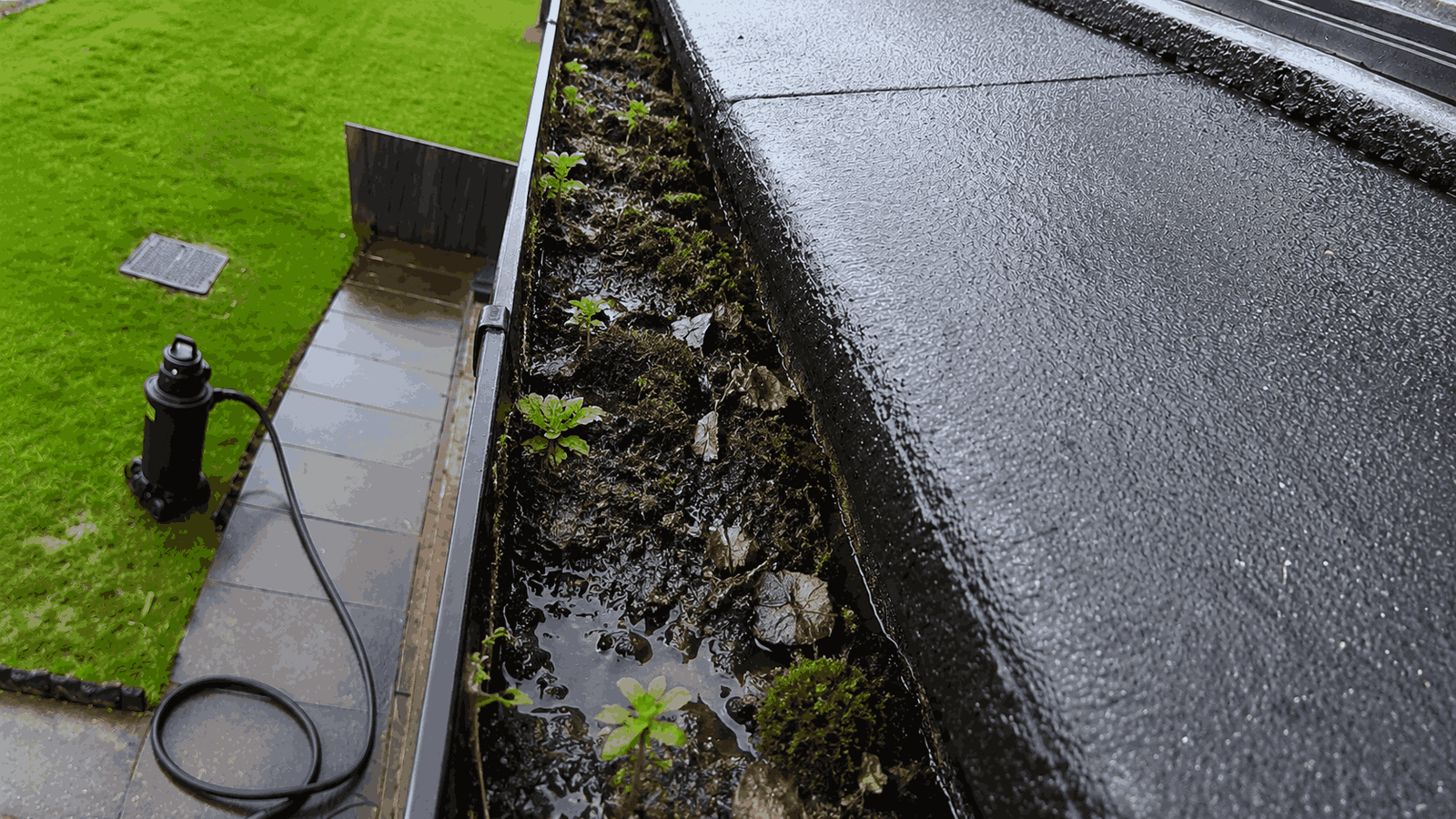 Before professional gutter clearance - heavy silt build-up and recurring standing water blockage